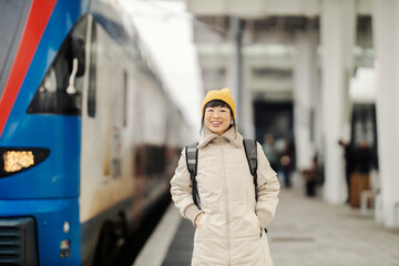 A japanese traveling woman standing at platform on train station near train.