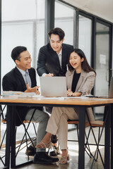 Young motivated Asian business team discussing oh business strategy in the modern meeting room.