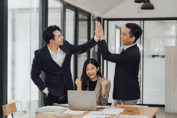 Young multiethnic diverse creative asian group huddle and high five hands together in office workshop with success or empower expression in teamwork. Young asian marketing team with copy space