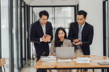 Young motivated Asian business team discussing oh business strategy in the modern meeting room.