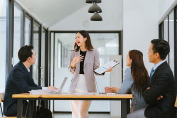 Young motivated Asian business team discussing oh business strategy in the modern meeting room.