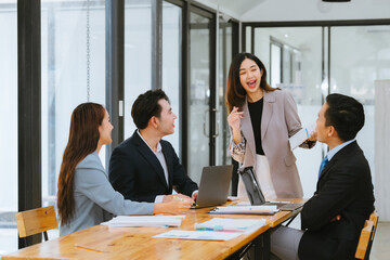 Young multiethnic diverse creative asian group huddle and high five hands together in office workshop with success or empower expression in teamwork. Young asian marketing team with copy space