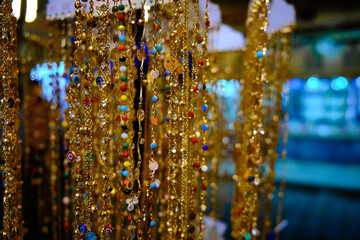 Row of golden jewelry bracelets and necklaces hanging at traditional middle eastern bazaar
