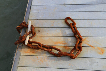 A closeup view of a piece of rusty chain left on the side of the jetty.