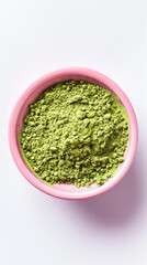 This close-up, top-view photograph captures the vibrant green of matcha powder in a stylish pink matte bowl, creating a visually pleasing contrast against the clean white background.