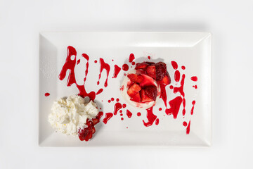 Panna cotta with cream and strawberries in rectangular white plate on white background