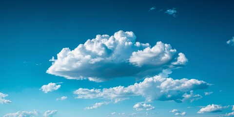 b'Large white cloud in a blue sky with smaller clouds around it' - obrazy, fototapety, plakaty