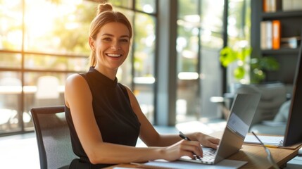 b'Smiling businesswoman working on laptop in modern office'