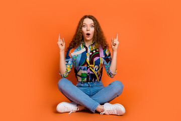 Photo of impressed nice adorable girl dressed stylish clothes empty space isolated on vivid orange color background