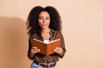 Photo of pensive puzzled clever girl with perming coiffure wear brown blouse hold book pouted lips...