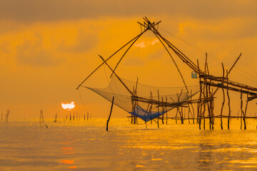 Sunrise and silhouette image of giant fishing net in the morning at Pakpra, Phatthalung, Thailand.