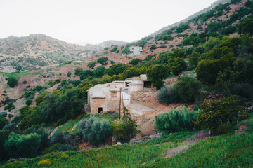 A building on a hill, overlooking the sky, trees, and mountains in Morocco
