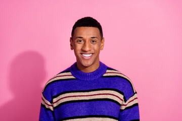 Photo of cheerful good mood man wear striped sweater smiling empty space isolated pink color background