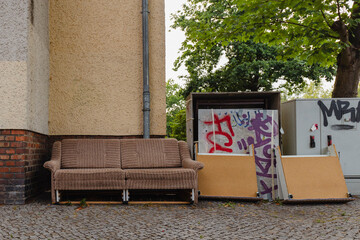 An old couch left on the sidewalk, bulky waste on the street, bulky waste in the city - obrazy, fototapety, plakaty