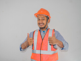 A man wearing construction hardhat smiling and give two thumbs up