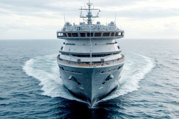 A large, modern ship is gracefully sailing through the calm blue ocean waters