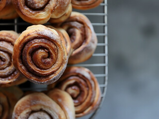 Cinnamon rolls lie on a cooling rack, close-up with icing