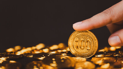 Explore the concept of wealth and investment with a businessman's hand picking up gold coins on a...