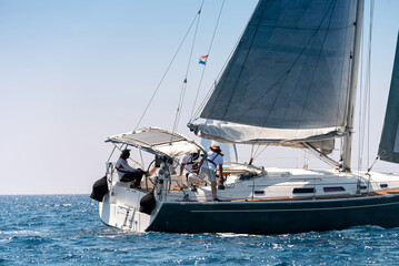 Close-up of a yacht with crew in open sea - 796525495