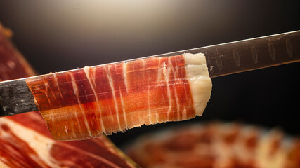 Jamon serrano de bellota. Thin slice of Spanish Iberian ham cut with a knife