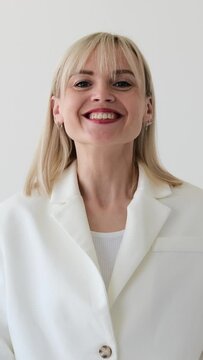 Surprised and excited Caucasian woman applauding in acceptance and saying wow on white background. Celebration, greeting concept. Vertical video.