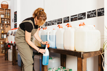 Woman Refilling Soap Dispenser at Zero-Waste Grocery Store During Daytime