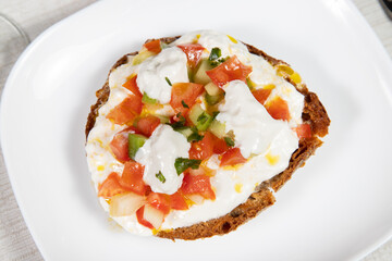 Frisella or Fresella typical south italian bread, Typical southern Italian bread. Frisella seasoned with olive oil, burrata buffalo mozzarella, cherry tomatoes and basil