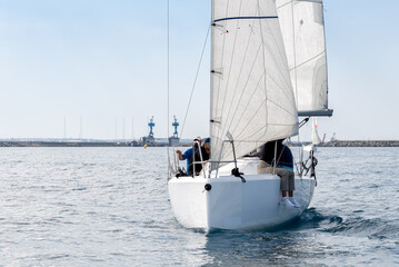 Racing yacht with white sails in a calm sea - 796535885