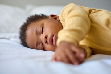 Close Up Of Sleeping Baby Girl Lying On Parent's Bed At Home