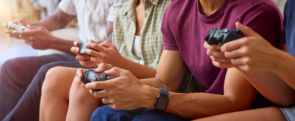 Close Up Of Group Of Excited Multi-Racial Friends Sitting On Sofa Playing Computer Games Together