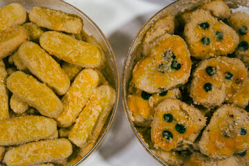 long cheese and peanut cookies served in round packaging on a plain white background, photographed close up