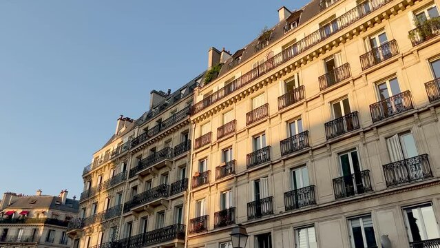 Bottom view footage of old, traditional buildings in Paris. It shows Parisian and French architectural style. It is a sunny summer day.