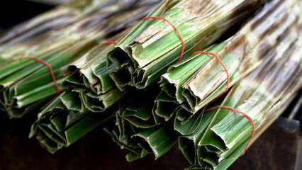 Thai sweetmeat made of flour, coconut and sugar wrap in palm leaves.