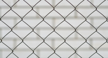 Fototapeta premium metal mesh and a brick wall behind it