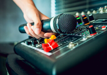 Hand Sound engineer  holding microphone on sound mixer in live broadcasting studio producer for...
