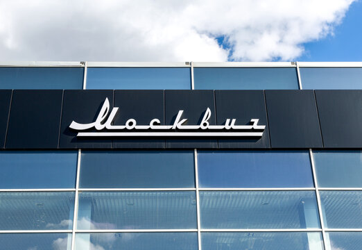 Official dealership sign of Moskvich on the wall of the office building