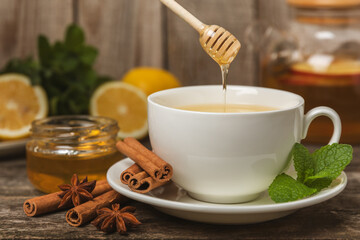 Fragrant hot tea with cinnamon stick and anise on a textured wooden background. A cup of hot tea...