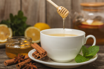 Fragrant hot tea with cinnamon stick and anise on a textured wooden background. A cup of hot tea...