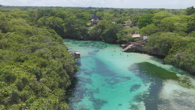 A beautiful blue river with a green forest in the background. The water is calm and clear, and the trees are lush and green. Sumba, Indonesia. 