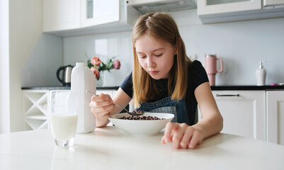 Girl Having Brown Chocolate Balls Cereal For Breakfast In The Kitchen In The Morning