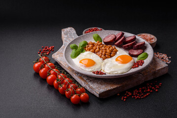 English breakfast with fried eggs, bacon, beans, tomatoes, spices and herbs