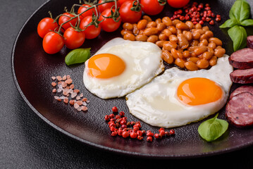 English breakfast with fried eggs, bacon, beans, tomatoes, spices and herbs