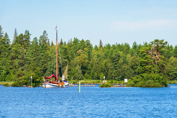 Idyllic summer view with a sailboat in a forest lake