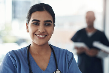 Portrait, nurse and happy woman in hospital for healthcare career, wellness and service in Brazil. Face, smile and young medical professional doctor, surgeon and expert employee working in clinic