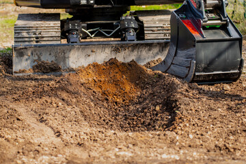 Excavated construction rubble and earth with modern excavator and bucket in the bckground