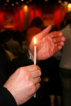 Taize community. Young man  praying with a candle.