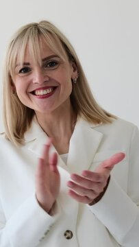 Cheerful Caucasian woman clapping hand in congratulation or agreement on white background. Acceptance or appreciation concept. Vertical video.
