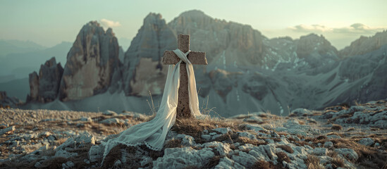 Picturesque landscape of an old wooden cross with a scarf of white fabric against a backdrop of mountains and sky. Faith, Orthodoxy, symbol of hope.