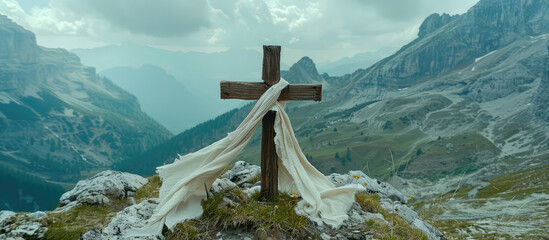 Picturesque landscape of an old wooden cross with a scarf of white fabric against a backdrop of mountains and blue sky. Faith, Orthodoxy, symbol of hope.