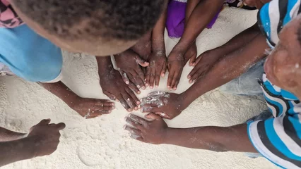 Deurstickers Kinderhände aus Afrika: Hände im weißen Sand auf Sansibar © Jeanette Dietl